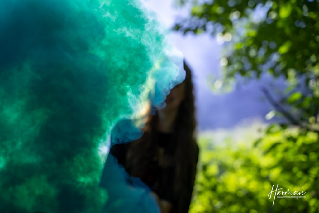 Female model Marina Krivonossova is surrounded by smoke during a smoke bomb photoshoot taking place in a nature park.